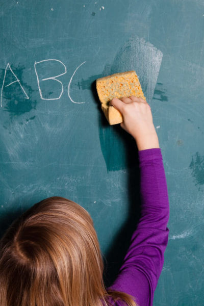 student wiping slate clean