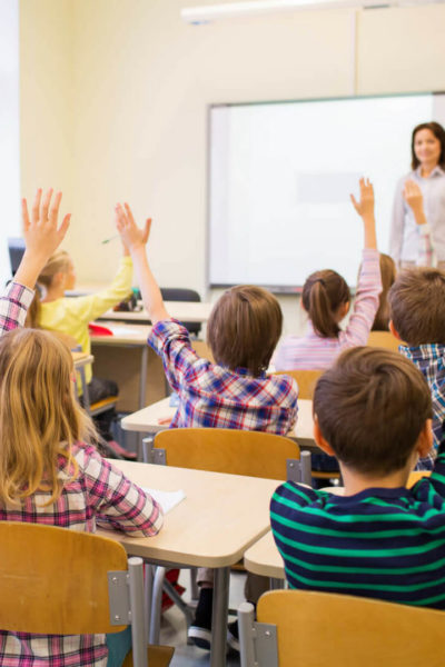 Class of Students Raising their Hands: Creating Classroom Culture with a Strong Classroom Management Plan