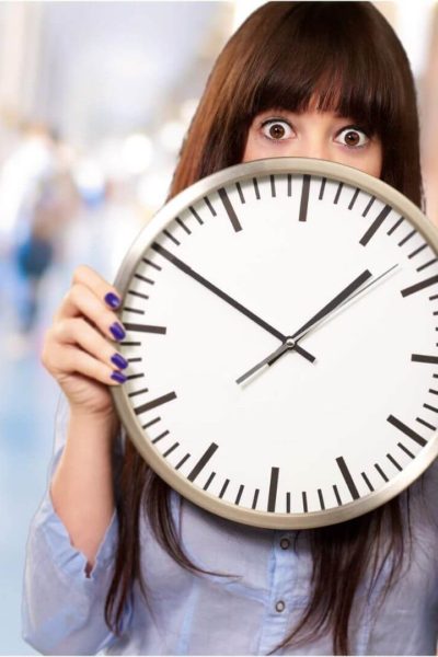 Overwhelmed teacher holding a clock