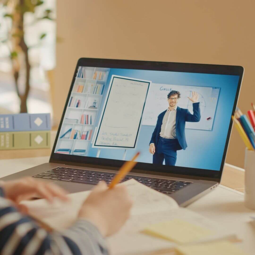 Male teacher teaching a student virtually